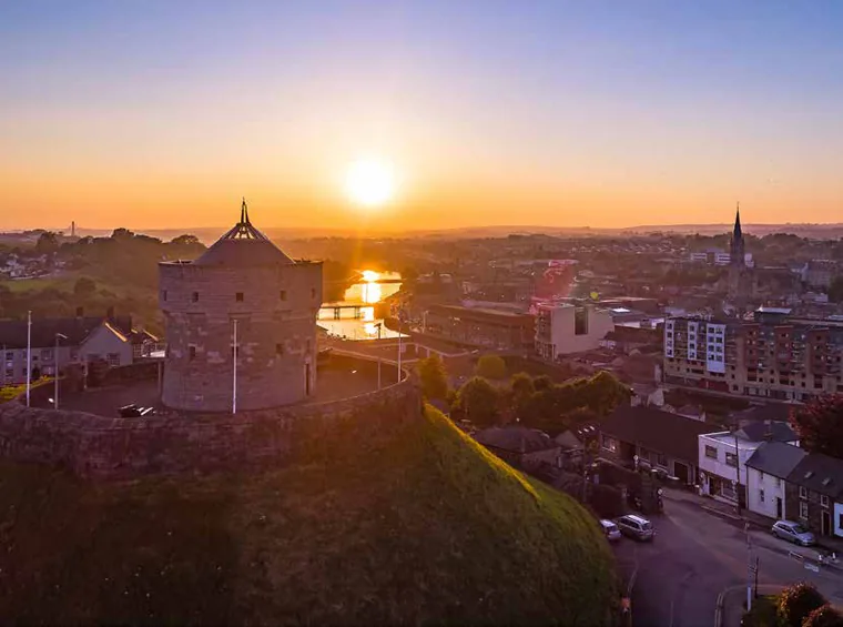 Millmount Martello Tower on a green hill above Drogheda at sunset with the River Boyne beyond