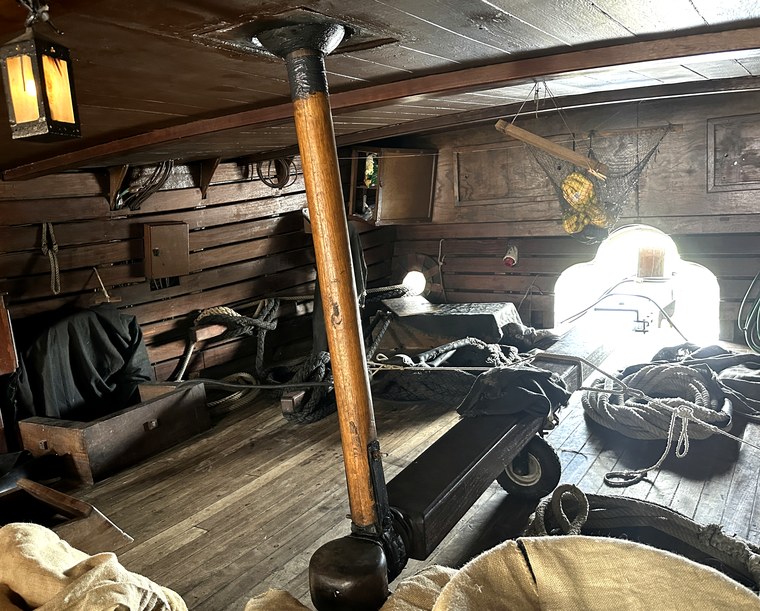 Below deck on the Nao Santa María: vertical whipstaff joined to a horizontal tiller beam aimed at the stern opening